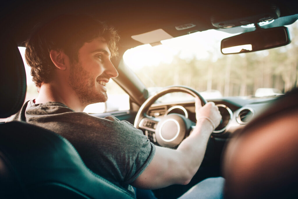 Glücklicher junge Mann am Steuer eines Autos